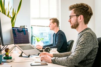 Two men sitting at a computer desk